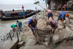 People work to repair the embankment designed to protect their island from river erosion. Satkhira, Bangladesh