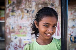 A young girl outside her parent's shop.