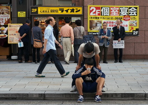Chinese father and son seriously looking into the same small screen  on smartphone