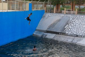 Kids jump from a high spot in the pool