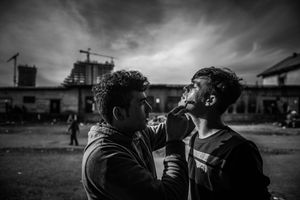 Men during shaving In temporary shelter behind main train station  in Belgrade, Serbia.