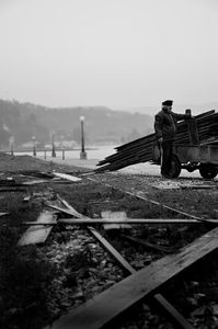 Collecting spare material from abandoned warehouses on the harbor in Aigion under the rain