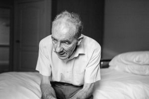 Sitting on his bed in his room in the care home he asks about other members of the family to see if they are also visiting at the same time.