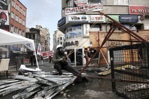 A protester wearing a gasmask pulls back on a makeshift slingshot during clashes in Taksim Square, Istanbul, Turkey. Tuesday, June 11, 2013.