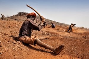 When there is no money to rent a pulverizing machine for crushing stones, the men do it manually, hitting the stones with hard sticks to crush them smaller. © Matjaz Krivic