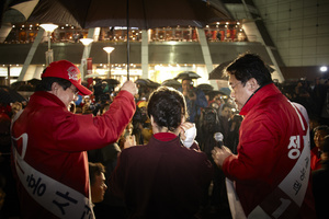Even during rainy nights, she gave her speeches.The bandage on her right hand is from the vast amounts of hands shaken, some harder than others.