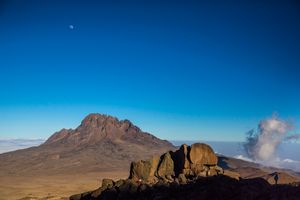 African woman farmers and the last warmth of sun at the base of Mount Kilimanjaro's Kibo Peak's summit climb.