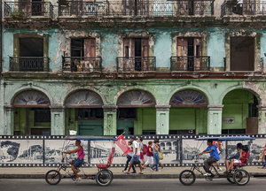 People and tri-cycle taxis along the Paseo de Martí in central Havana.