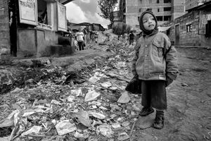 © Tony Corocher - I ran into this little boy the first day I entered Mathare Slum. He was going to school. What struck me immediately was the label on his jacket… "Strong"… it looked like some kind of encouragement to keep going despite the terrible surroundings and conditions. Behind him one of the streets that leads into one of the most dangerous slums in the world.