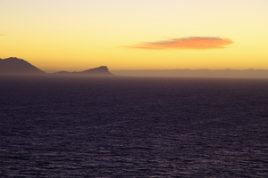 Sunrise, False Bay / False Bay and Kogelberg at 5:00am, seen from Smitswinkel Bay, at the other end of the large stretch of ocean known as False Bay, near the southern tip of South Africa.In the mist at the bottom of the coastal mountains are Pringle Bay and the other villages located along the road between Gordon's Bay and Hermanus. In the sea, plenty of whales, sharks and other marine life.