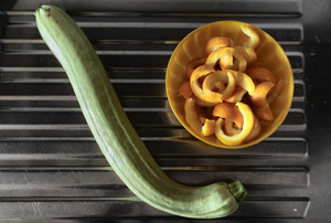 Kitchen. A courgette and some orange peels, ready to be candied.