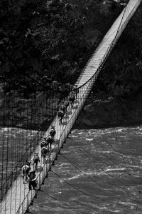 Pack horses cross the Shi Yi Luo bridge across the Yalong River south of 7000-metre Gonggashan. © Michael Freeman