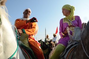 Riding mentor and "sorba" member  offers some advise to a young woman rider as they corral waiting for their charge. Oued Merzeg, Morocco