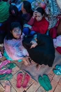 Women left homeless when their homes were destroyed by the 2015 Nepal earthquake shelter in a temporary camp.