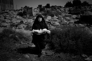 © Christian Werner - Iraq, Basra, 24 April 2012 – An old woman carries the linen-wrapped body of a stillborn child at the children’s graveyard in Basrah.