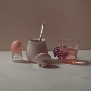 Still life in Morandi style with a pink egg and crumpled paper