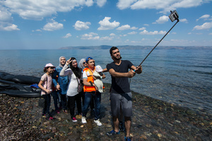 Families from Syria take selfies at the beach. More than 30,000 refugees have reached the Greek island of Lesvos during August 2015, according to Amnesty International. August 22, 2015, Lesvos, Greece
