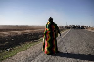 A Kudish woman in traditional uniform waits the procession before the funeral of YPG and YPJ fighters in Suruc, Turkey on November 7, 2014.