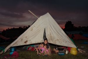 Children from a family left homeless by the 2015 Nepal earthquake inside a tent at a refugee camp for internally displaced people.