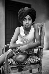 A young boy sitting in an old chair 02 | Dhanda, Punjab.
