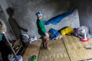 Porn Veuon 45 from Pursat Province walks arose the wooden planking on the floor of a construction site that she and her family call home. Veuon started working in construction 1 year ago. She moved to Phnom Penh with her husband and 5 children.