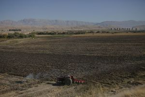 General view of the city and fields . A man is plowing the field