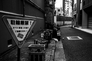 A man take a rest after a day work in a small street of Shinjuku