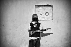 A gang member pose for a photo in Carapita, a slum in west Caracas.