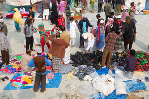 Many people seat on street near the Istema camp to sell products