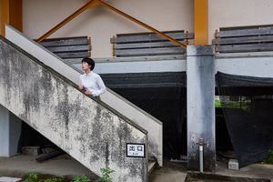 ‘Reclaimed by Nature or Man’, The Japanese girl standing on the stairs almost statue like pose for a photo by her friends.