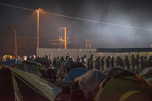 Refugees in the Idomeni camp line up in the rain for food. March 23, 2016.