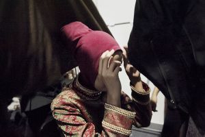 Backstage Jakarta Fashion Week. Model fixes the ninja cap before wearing the hijab.
