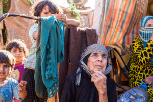 Bekaa Valley, LEBANON, September 5, 2014: Syrian refugee Aida el Issa (79, center), and her grandson Amjad (7, center left) fled from Syria over night three years ago, when news occurred that their village was going to be bombed. They don’t know what happened to their house since then.