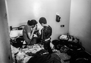 Soukaina in here bedroom putting on make up with here little brother