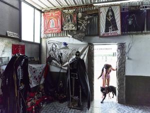 Young girl responsible of the San la Muerte temple in the Buenos Aires suburbs of San Vicente, with her dog