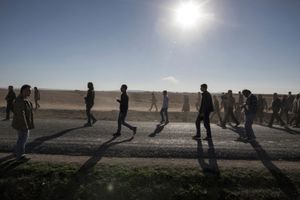 People walk in front of a coffin during the procession before the funeral of YPG and YPJ fighters in Suruc, Turkey on November 7, 2014.