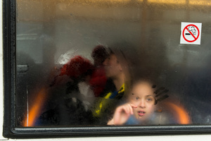 Doodling on a wet bus window.