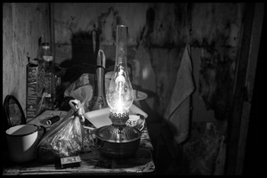 A sparingly oil lamp illuminates the space.