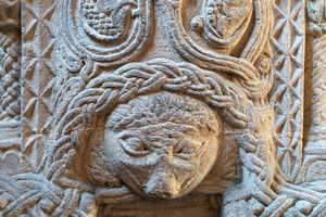 A man struggles to escape tendrils on the font at St. Peter's, Shernborne