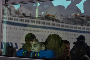 A young refugee looks outside the window after boarding a bus at Piraeus port. Thousands refugees were arriving from the islands during 2015.