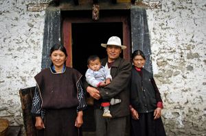 Three generations of a Milin village family, Tibet photographed outside their home. © Forest McMullin