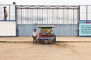 Phnom Penh, Cambodia. Jan 2013. Peddler in front of an under construction site, he sells drinks to the workers. Aeon Mall (Cambodia), a japanese developer, is building a US$ 205 million mall. 68400 sq.m including 150 large retail units, a cinema complex (1000 seats) and 15000 sq.m of entertainment space. It will create more than 2000 jobs.