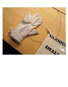 Plate 6:  Two gloves and Ed Ruscha's artist's book "VARIOUS SMALL FIRES and Milk," 1964, photo 2006-LK.