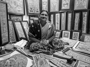 A painter exhibiting her work at the local market.