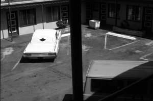 MOTEL PARKING LOT WITH WHITE CAR