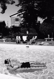 Bruno does some calls on pool's mattress, on the back Alessandro and Francesco tan themself.