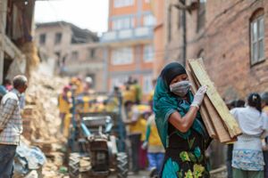 Volunteers and NGO workers help to clear the rubble from buildings destroyed by the 2015 Nepal earthquake.