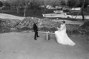 A newly-wed couple pose for photographs while sitting on a child's see-saw in the partially built Macka Park.
