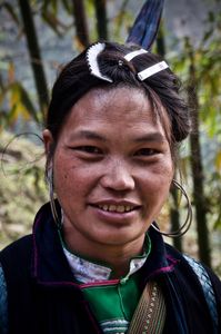 Young H'mong girl wearing her hair pulled up on her head and clipped several times using slides and a hair comb.