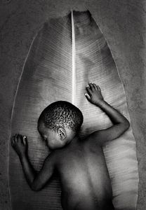 The picture of Seintongo lying asleep on the leaf of a plane tree, the father of banana trees. Seintongo’s family members are experts in the cultivations of plane and banana trees, they preserve endemic species and reject the new hybrid seeds coming from Kenya © Nicola Angelo Mangia